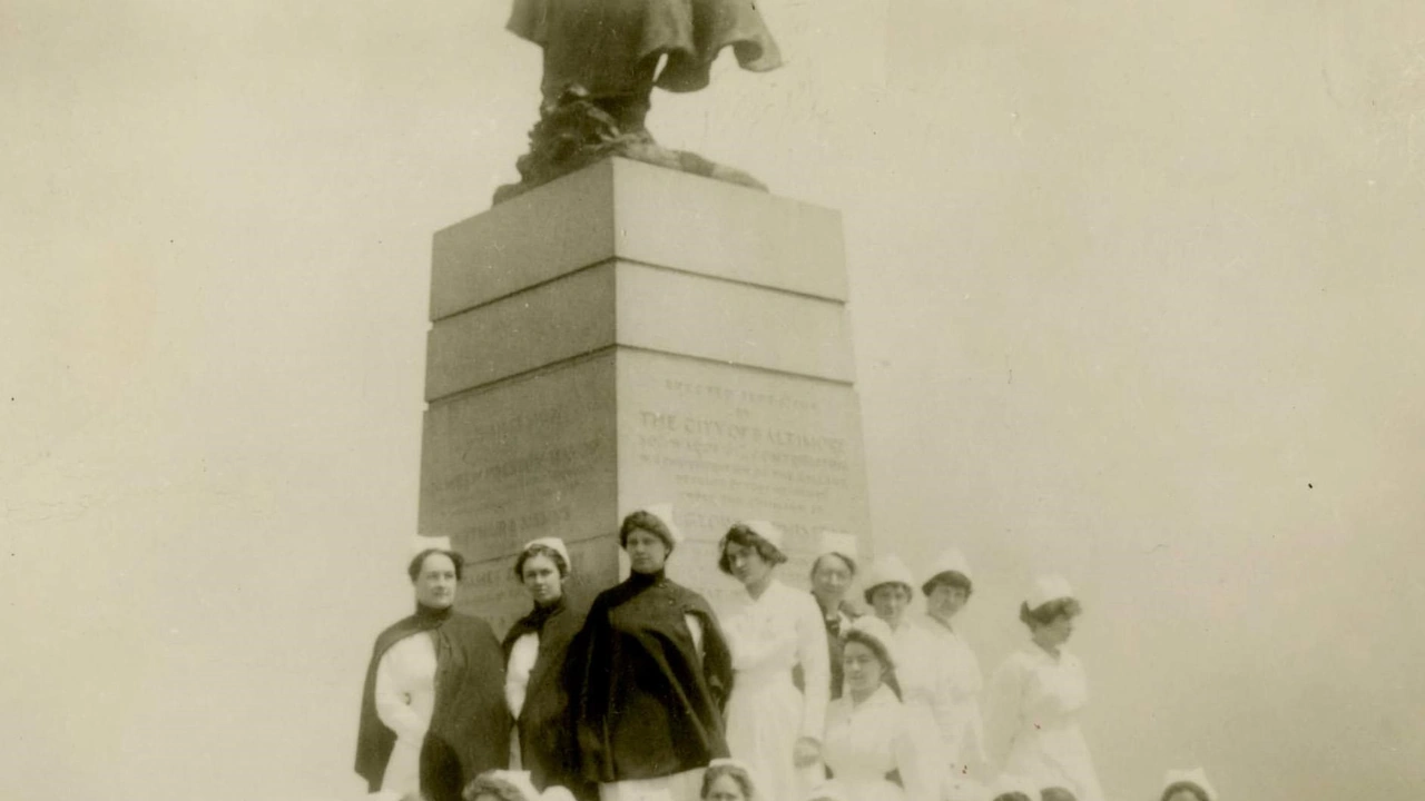 A vintage photo of nurses posed by a monument