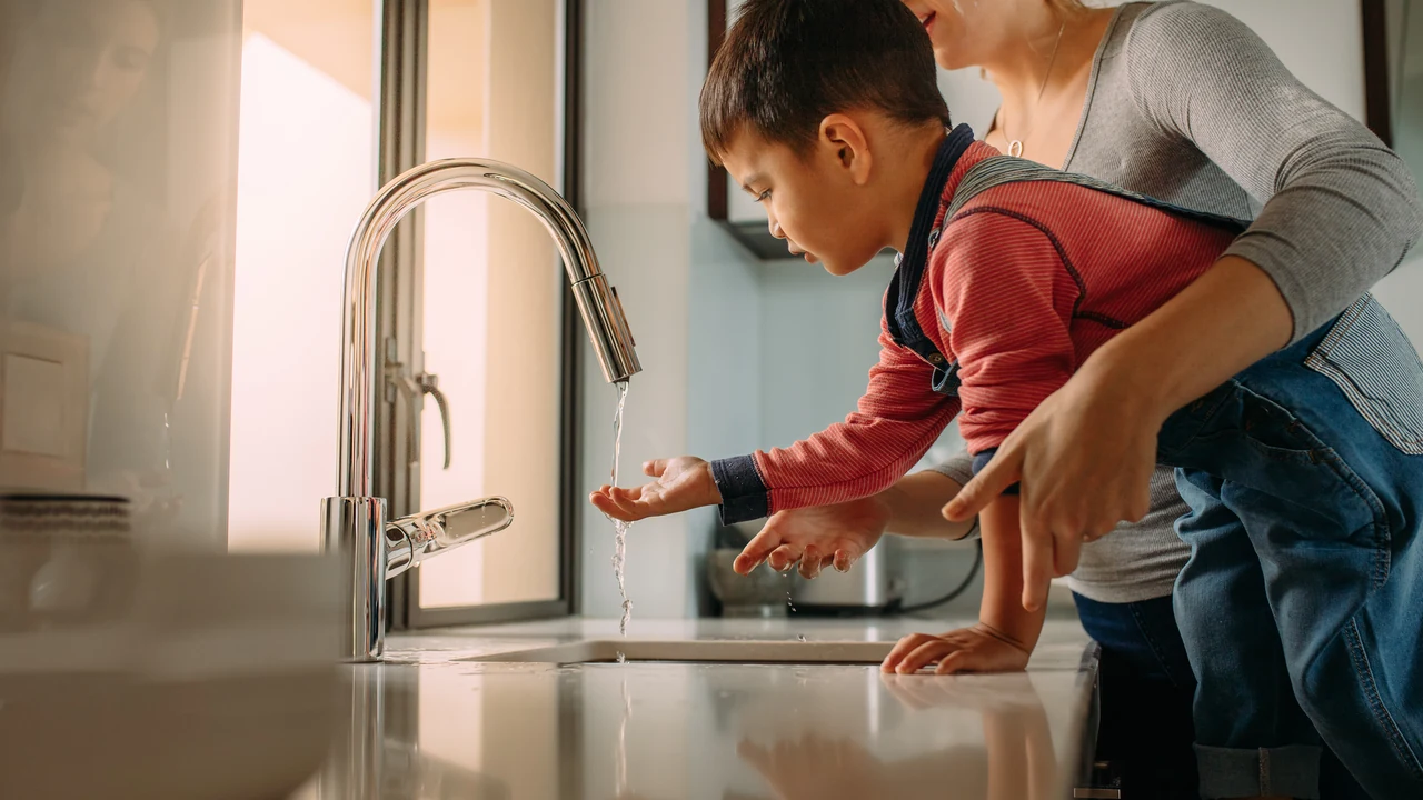 Kids wash their hands at a kitchen sink