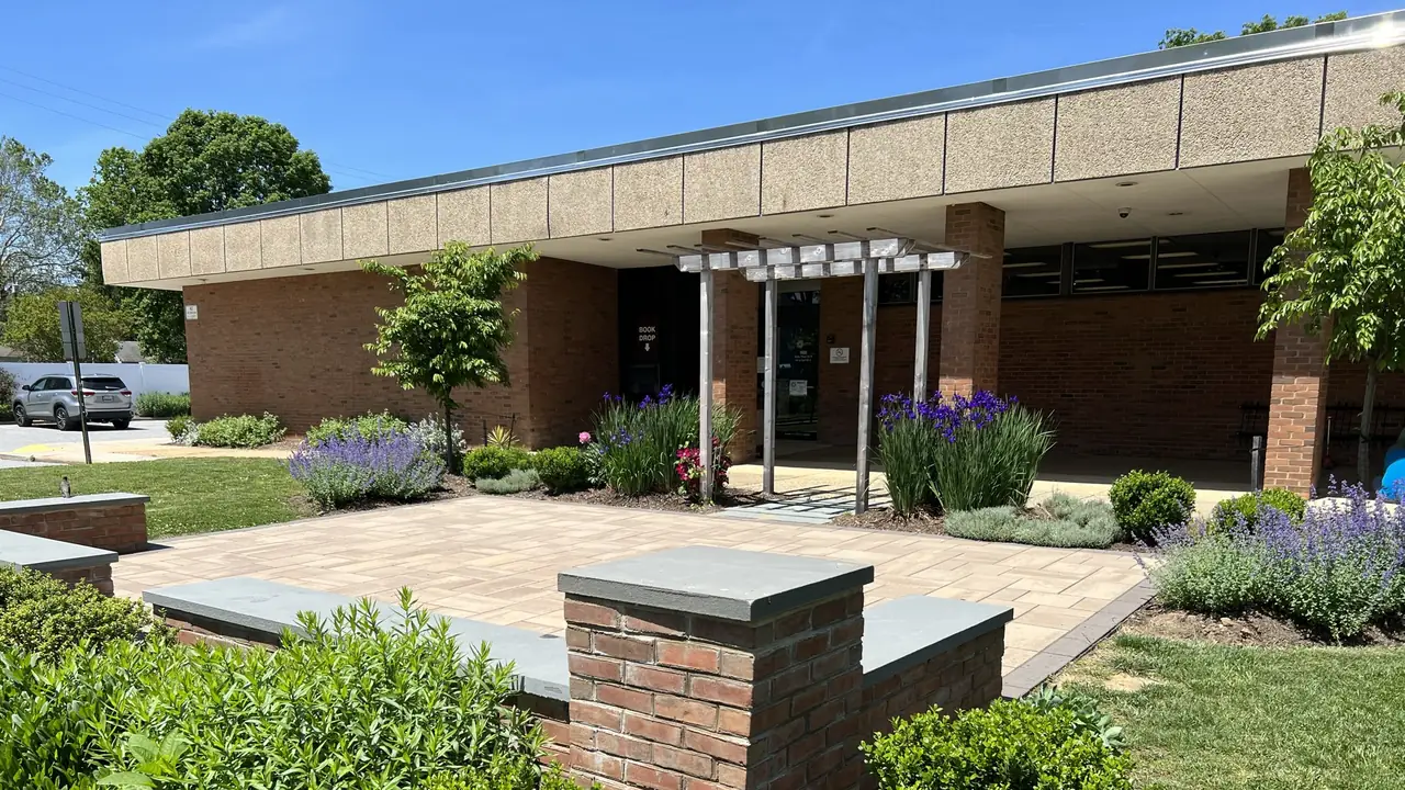 A brick library entrance with a garden