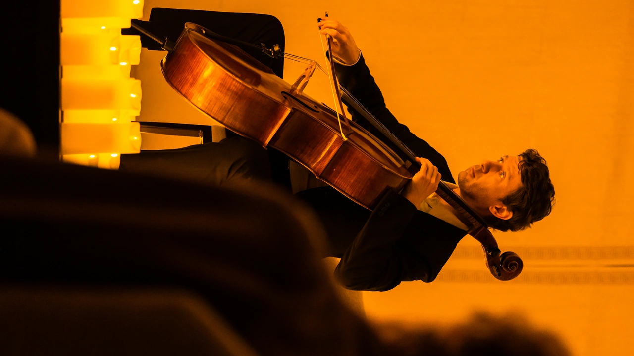 A cellist plays in warm orange light