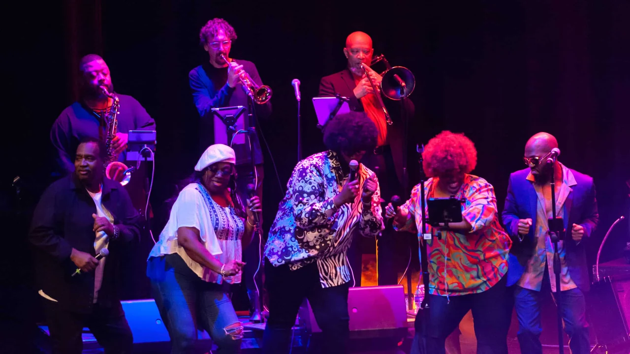 A funk band performs under purple lights