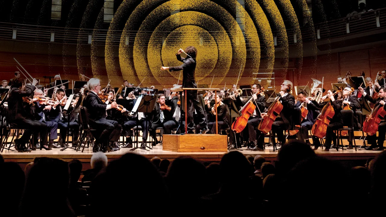 An orchestra performs on a concert stage