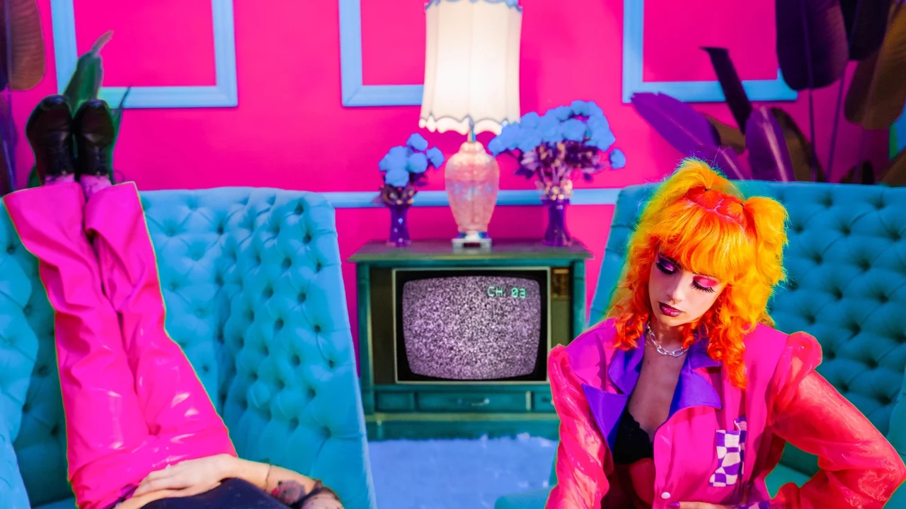 A performer in a bright pink retro room