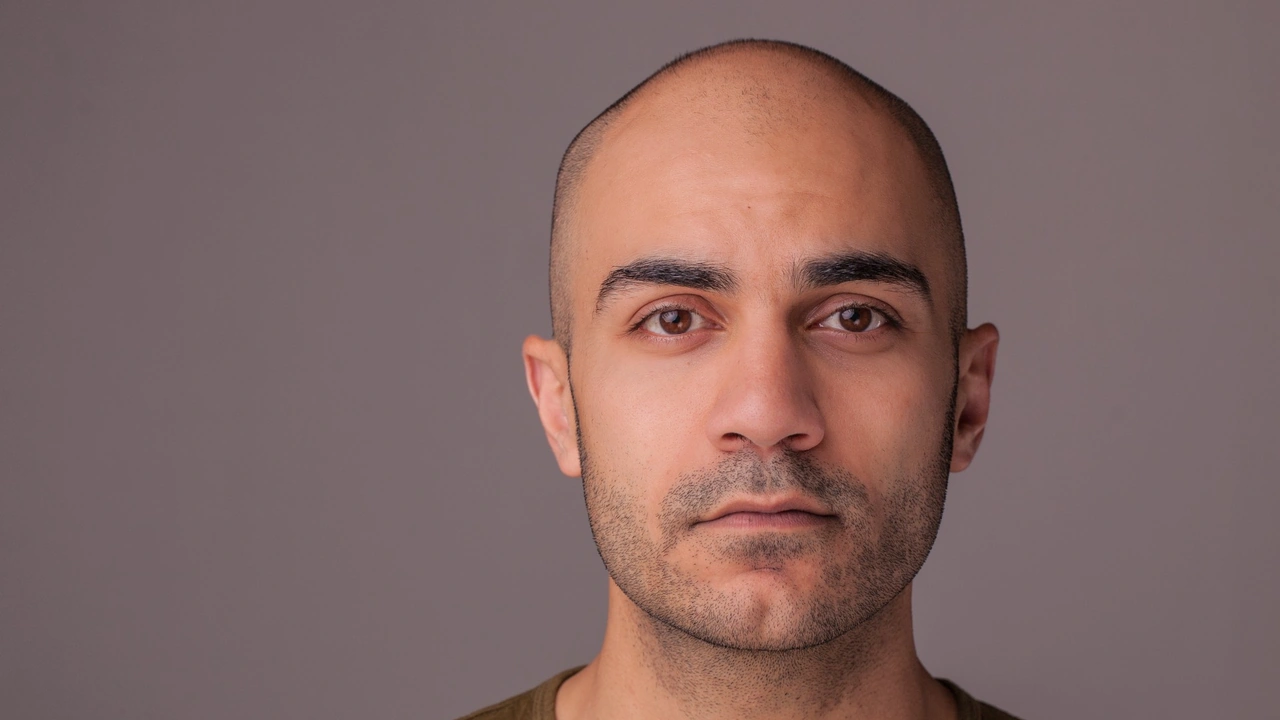 A portrait of a man against a gray backdrop