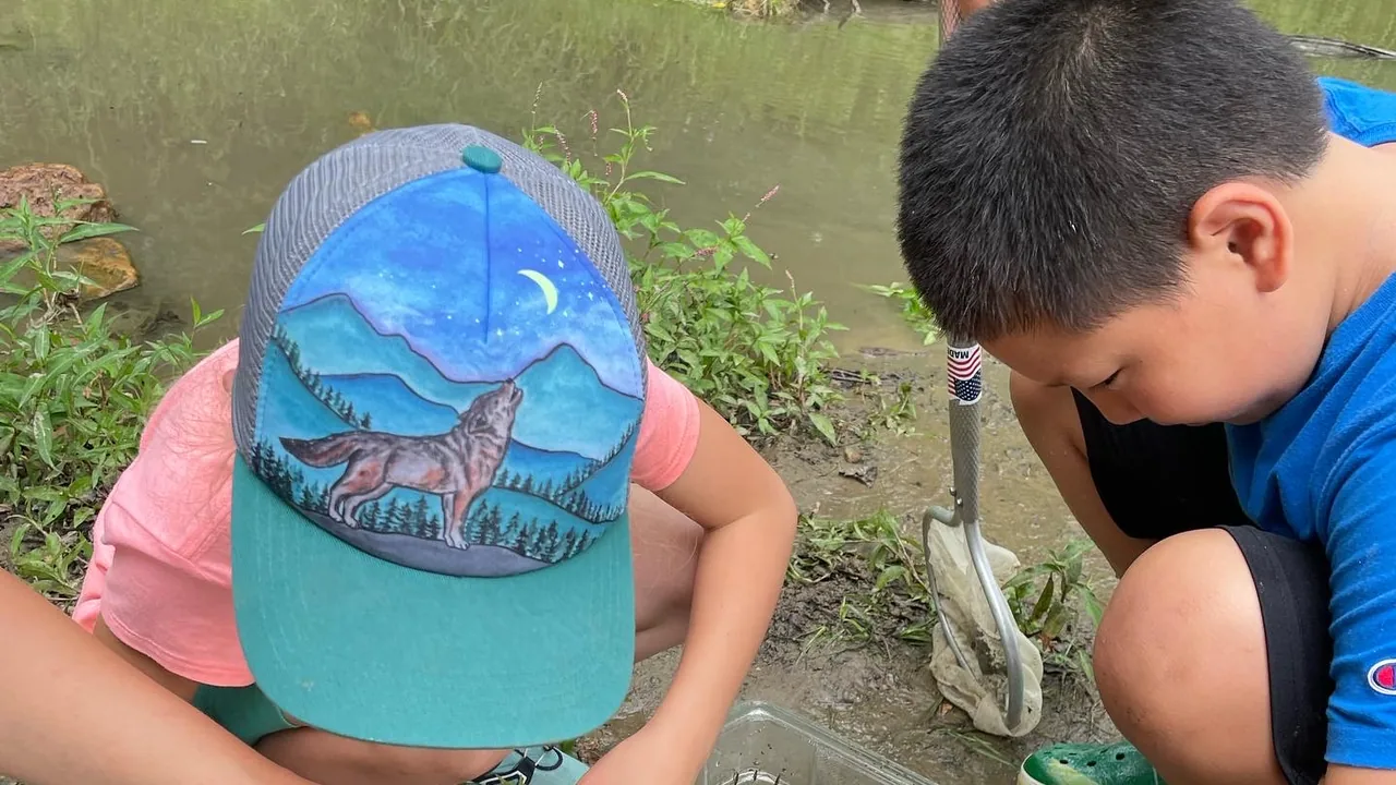 Two kids dig in a garden bed
