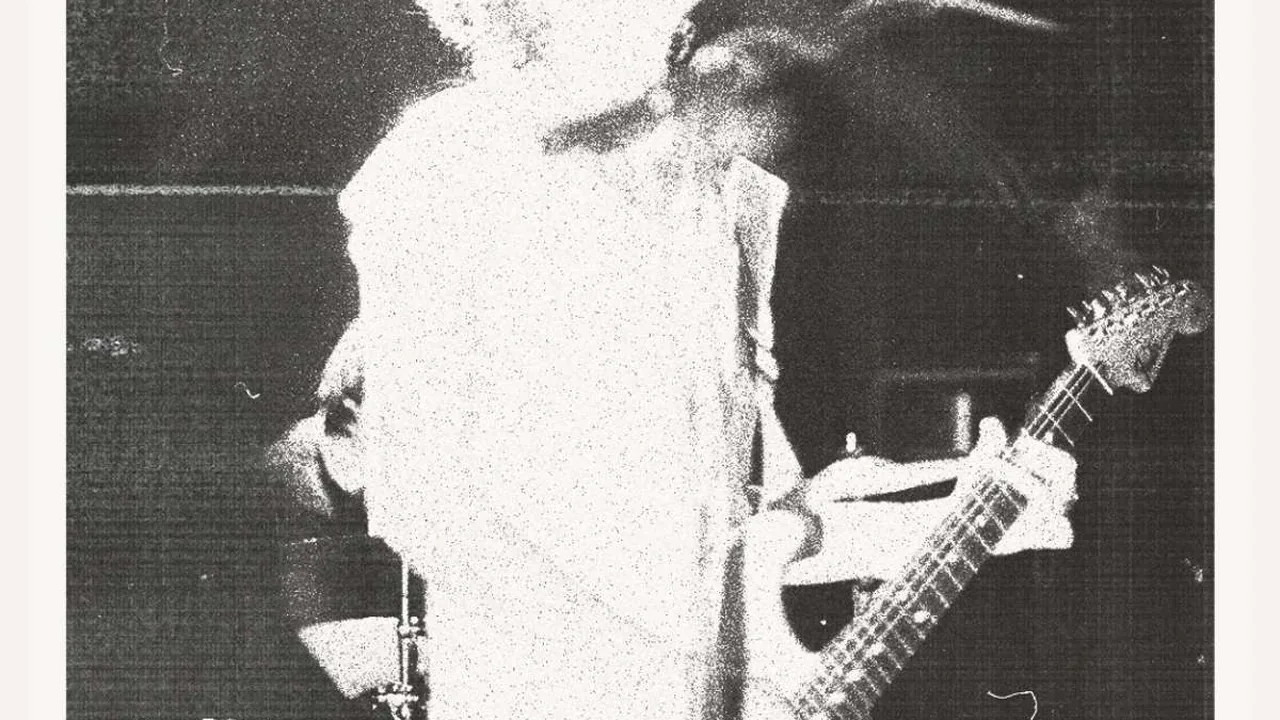 A guitarist in grainy black and white