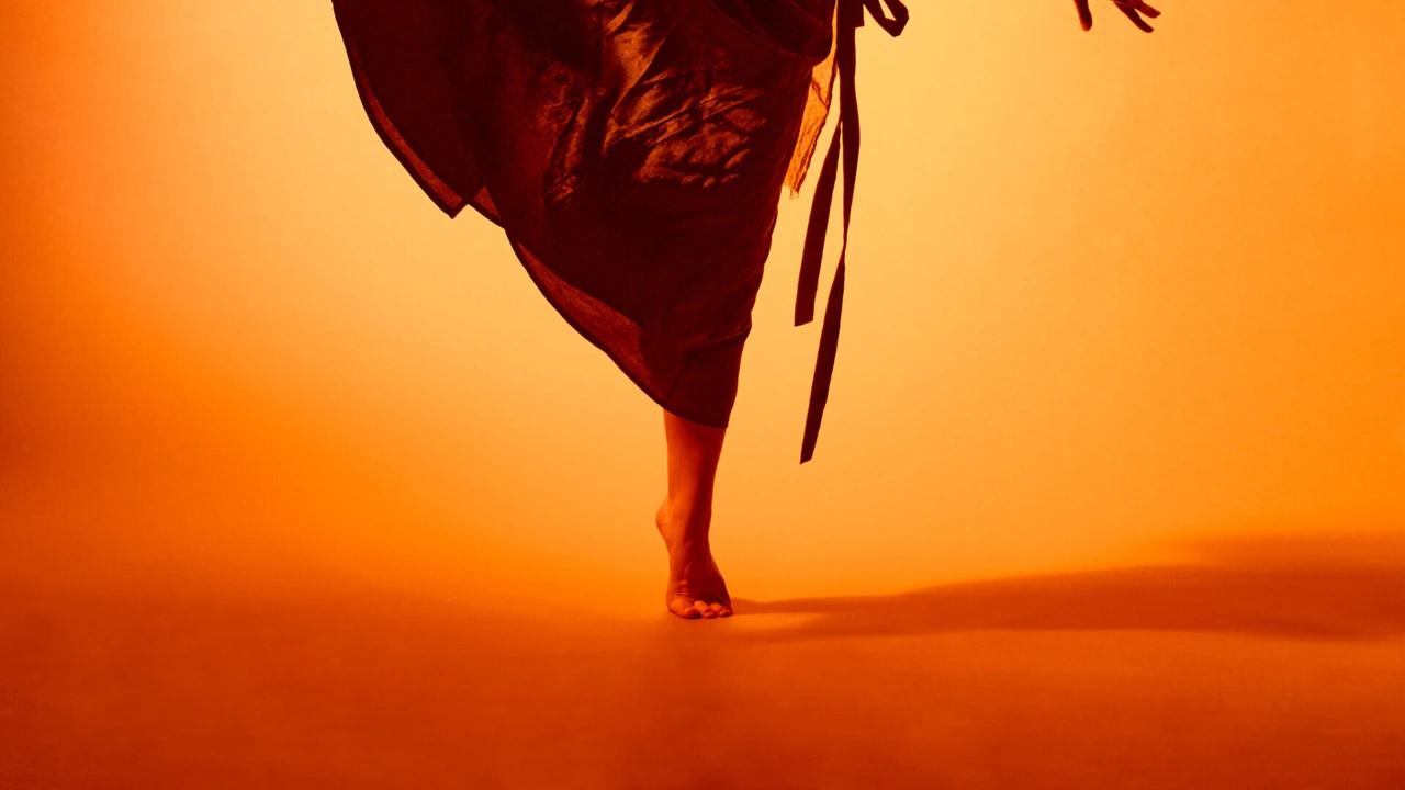 A dancer in red against an orange glow