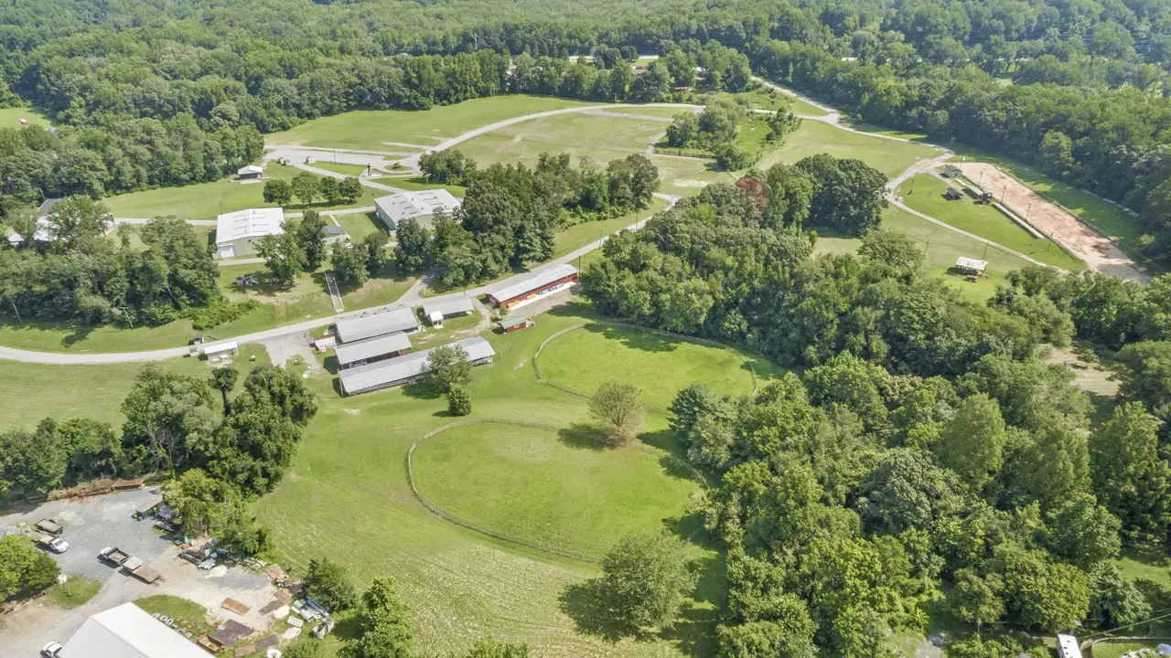 Aerial view of rolling farm fields, wooded areas and barns.