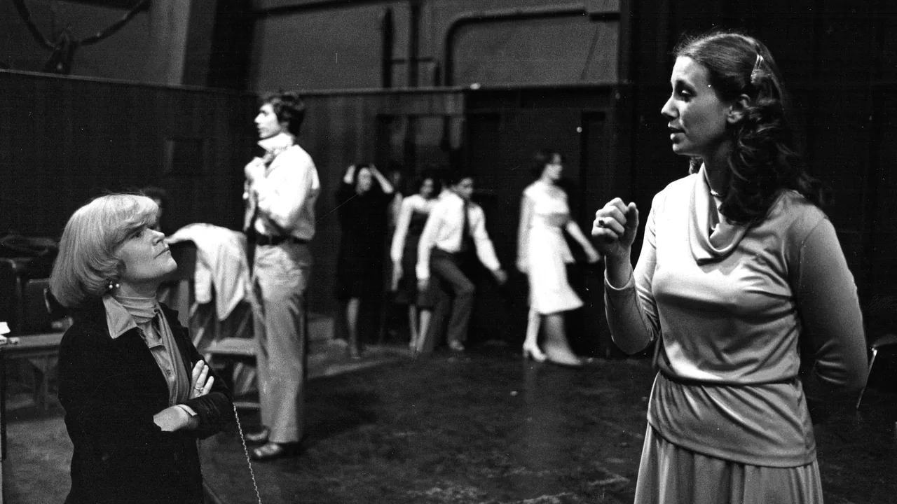 Black-and-white photo of actors rehearsing on a stage