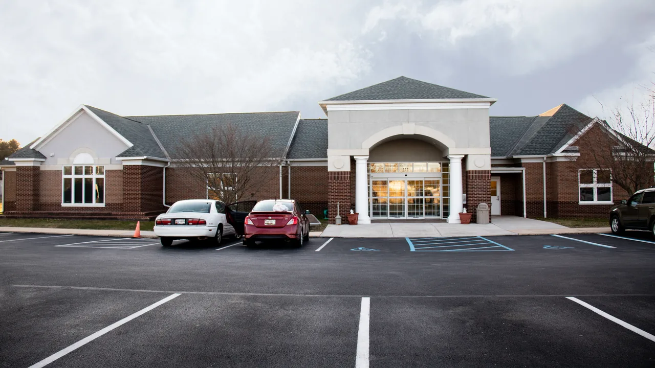 A brick building with a white portico