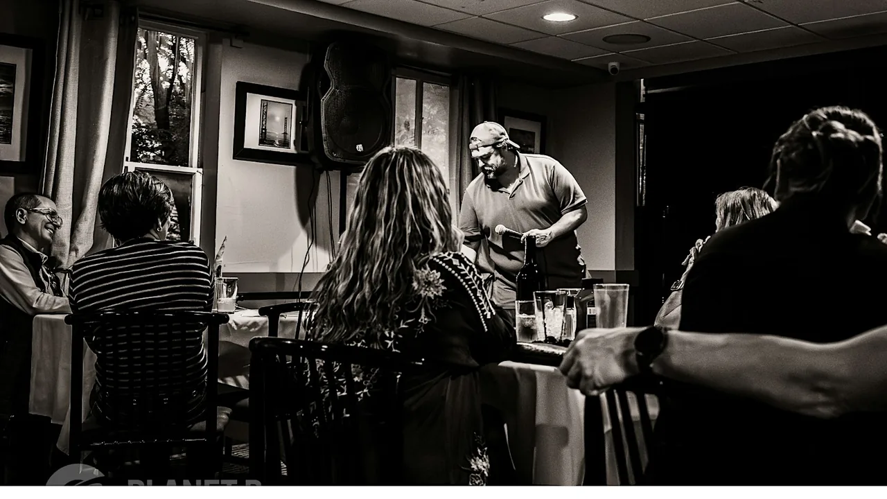 Patrons relax in a dim lounge in black and white