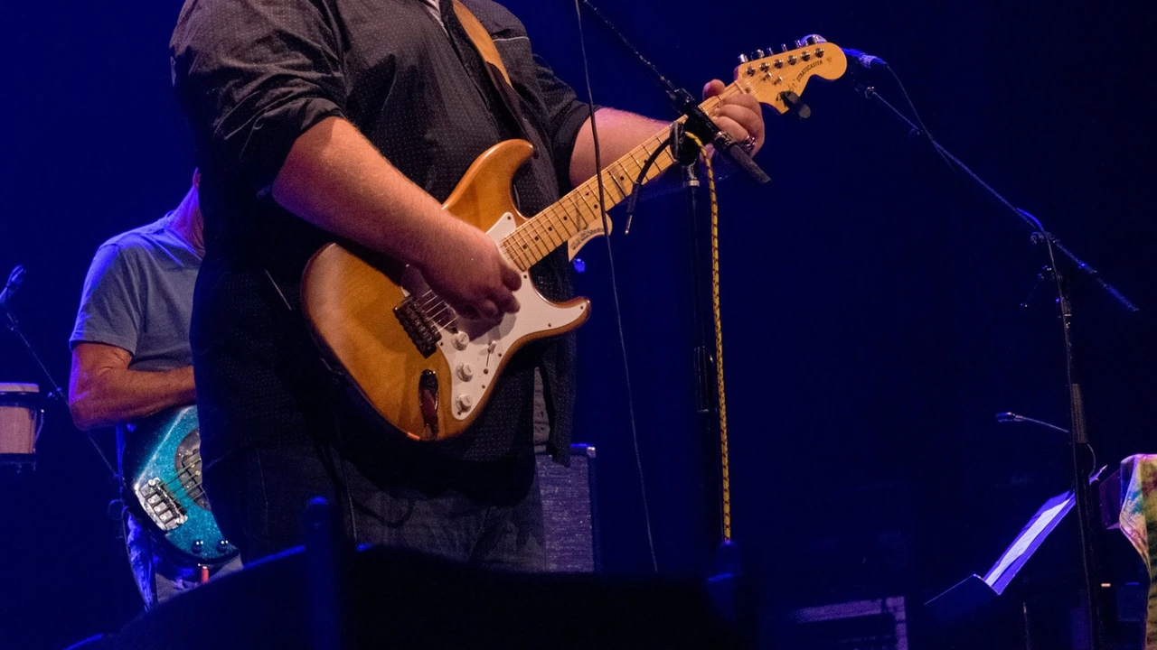 A guitarist plays under blue stage lights