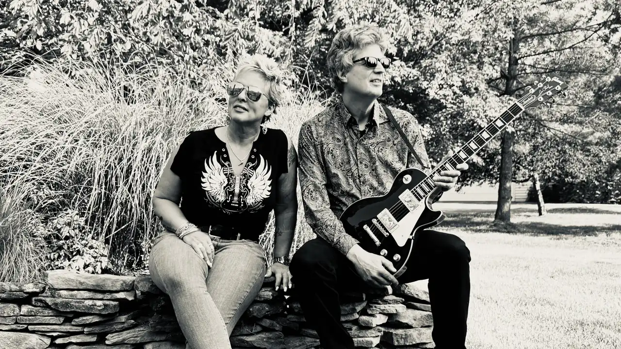 A duo with guitar in black and white