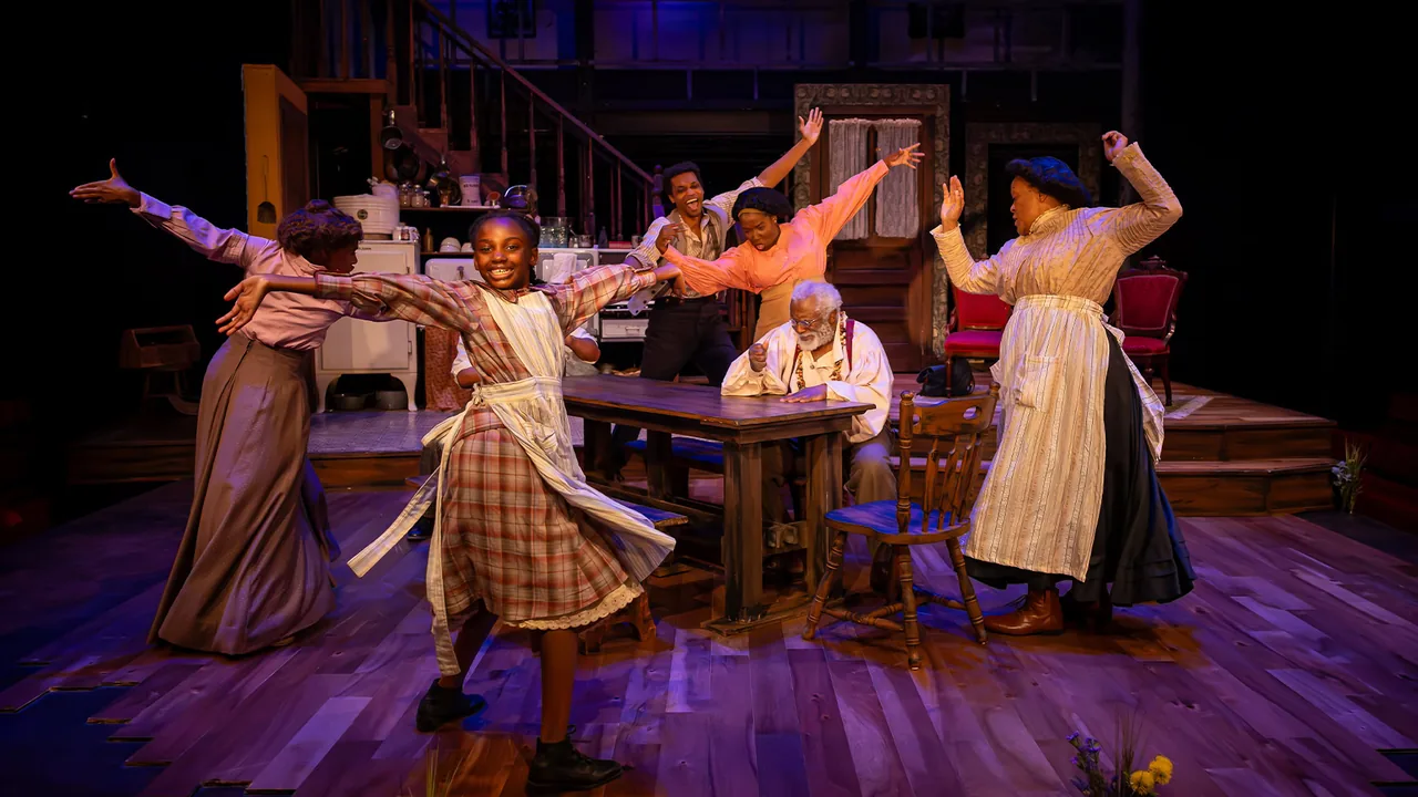 Actors in period costume perform on a lit stage set with a staircase and a table