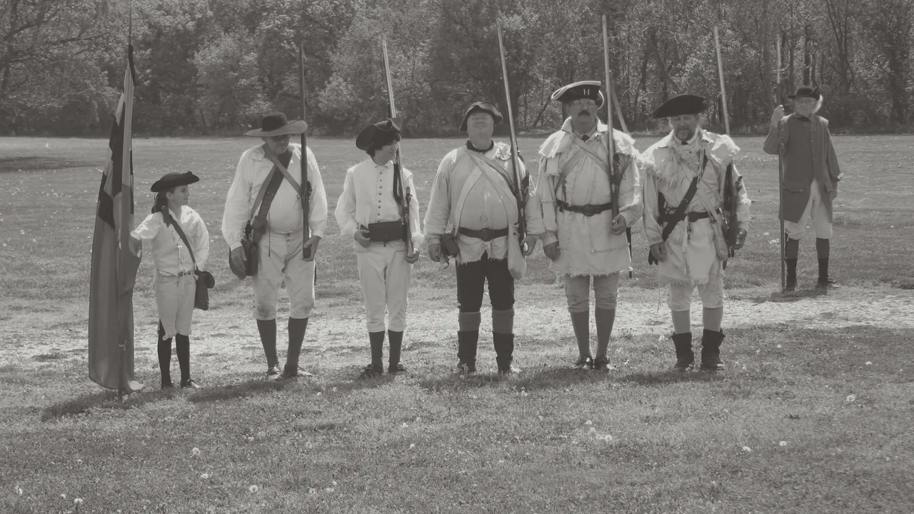 Reenactors in colonial dress on a field