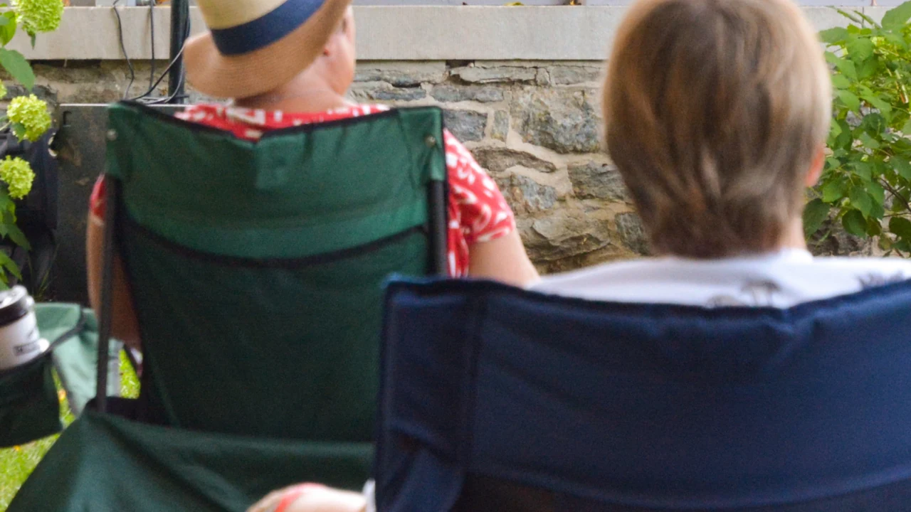 Two people relax in lawn chairs outdoors