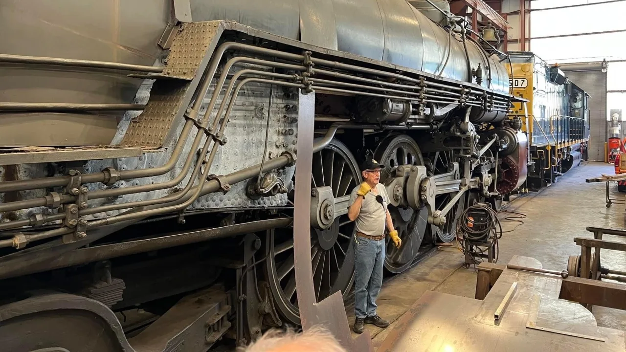A child looks up at a restored steam locomotive