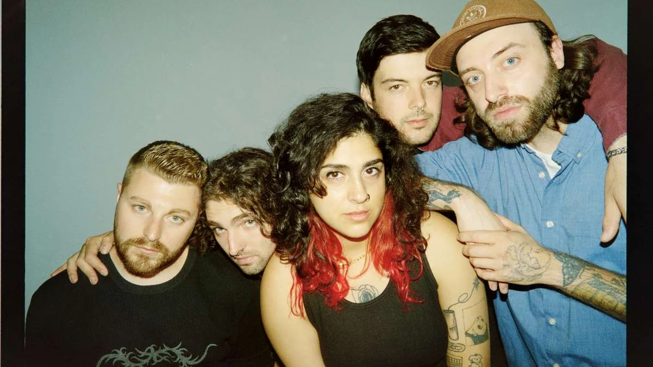 Five band members pose close together