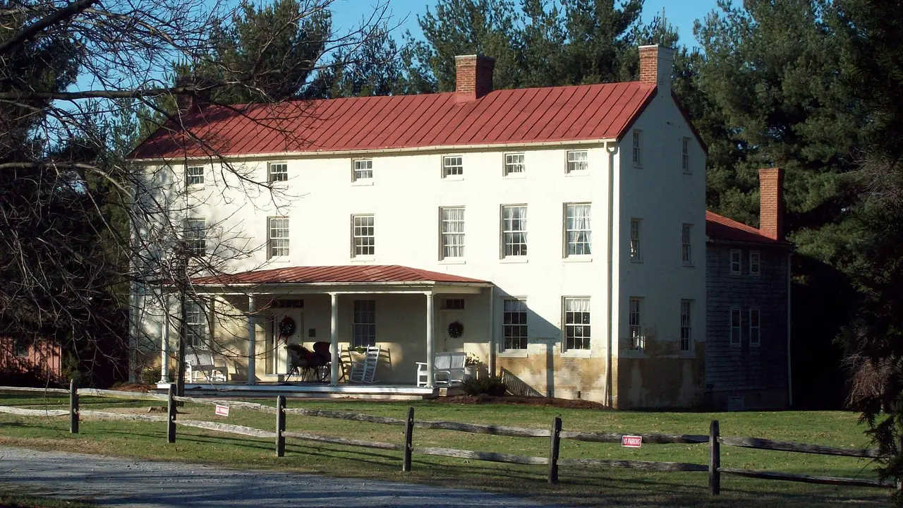 A white historic house with a red roof