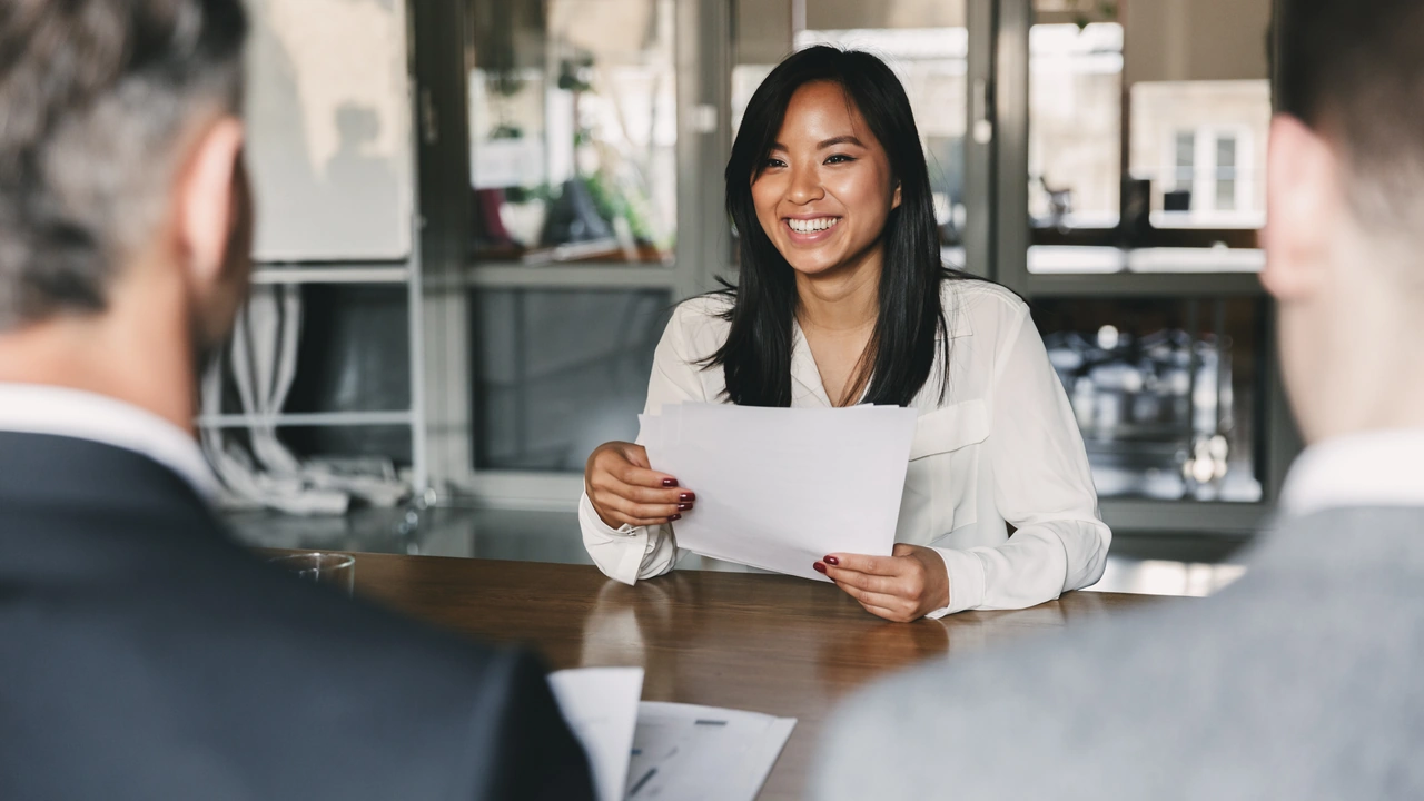 A woman reviews papers at a meeting table