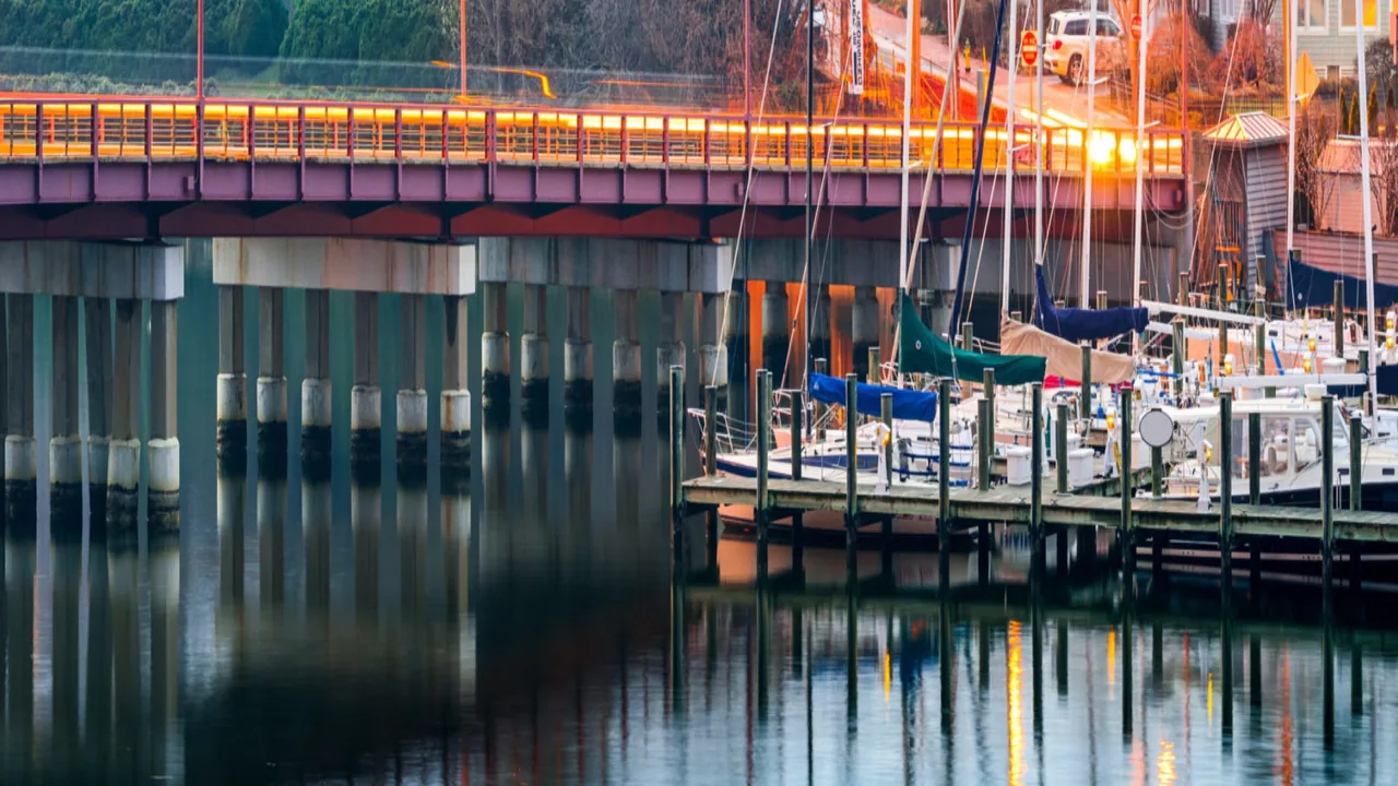 Boats moored beneath a bridge at a marina