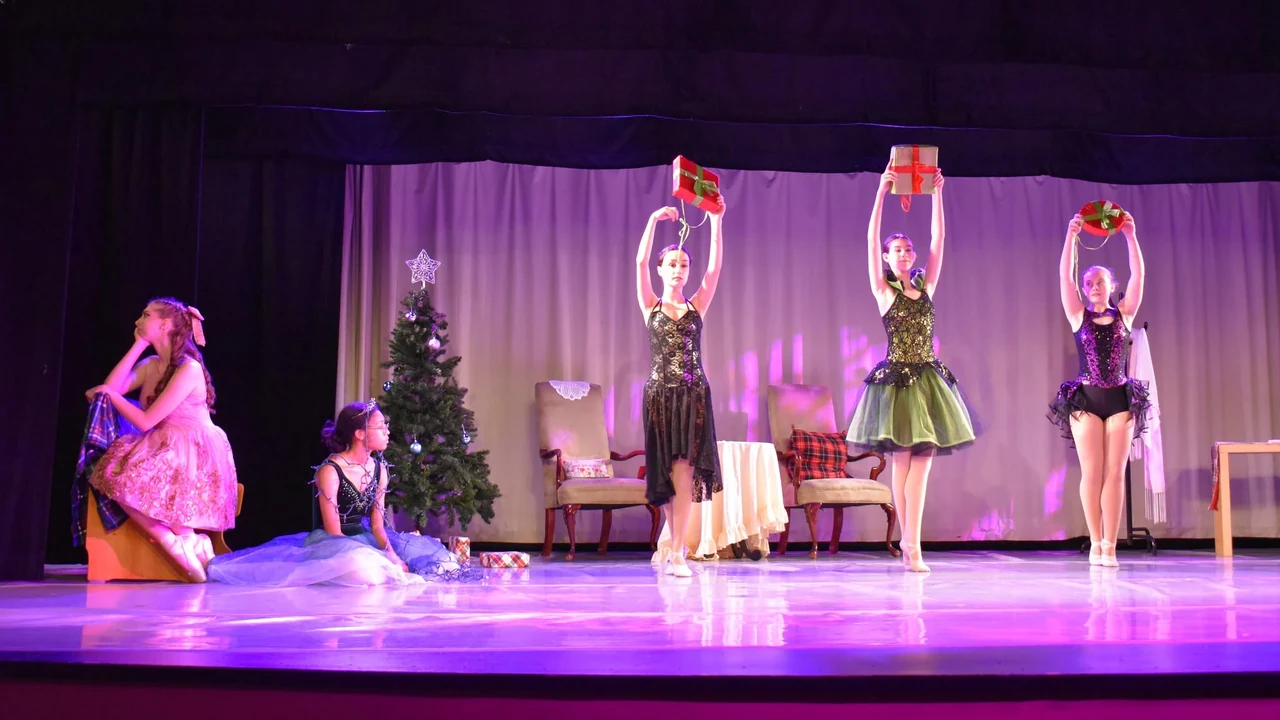 Dancers perform on a holiday-lit stage