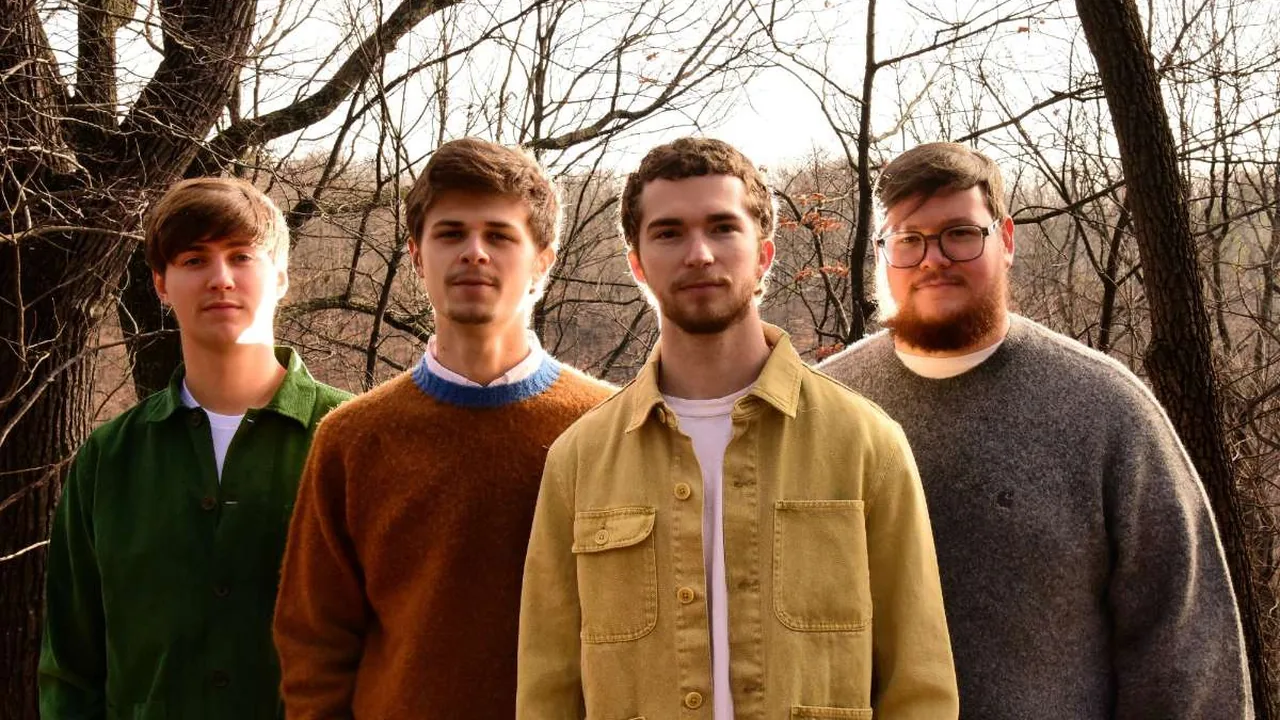 Four young men stand in a winter woods