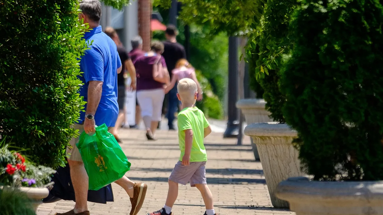 People stroll down a shady garden path