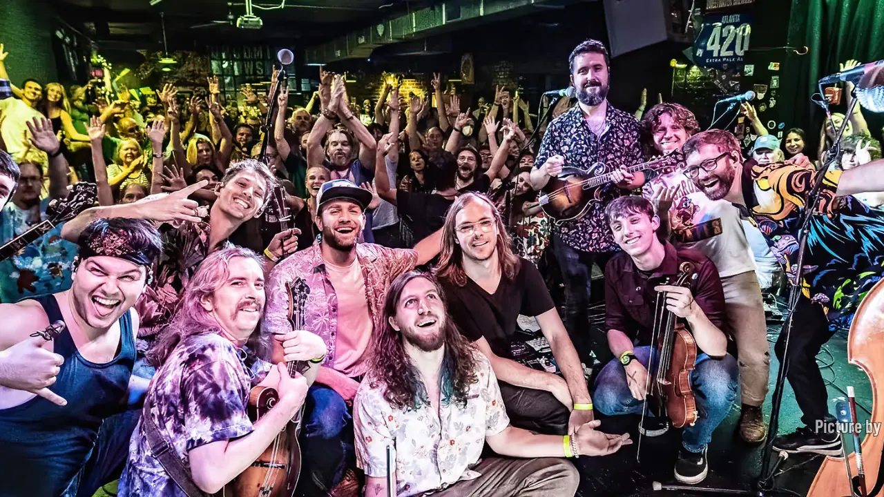 A crowd packs the stage with a band after a show