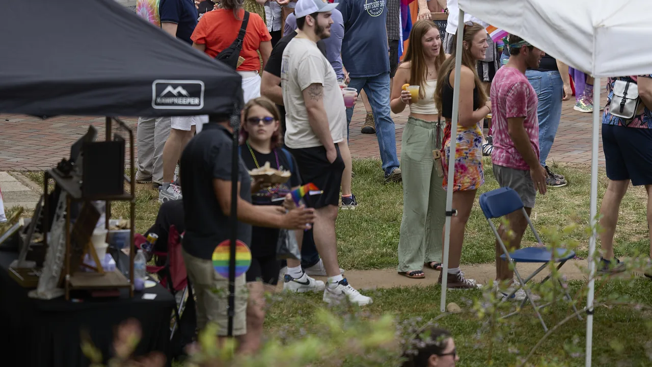 People gather around a tent at an outdoor fair