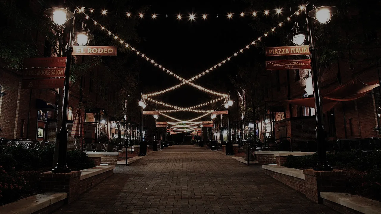 String lights crisscross a quiet downtown street at night