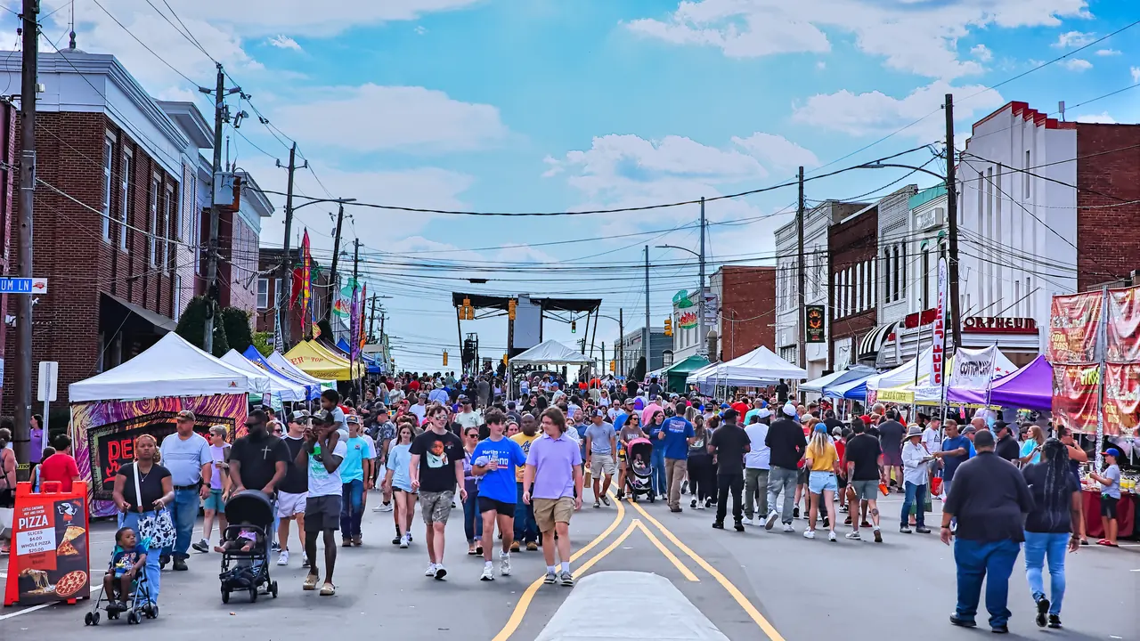 Crowds fill a downtown street lined with tents