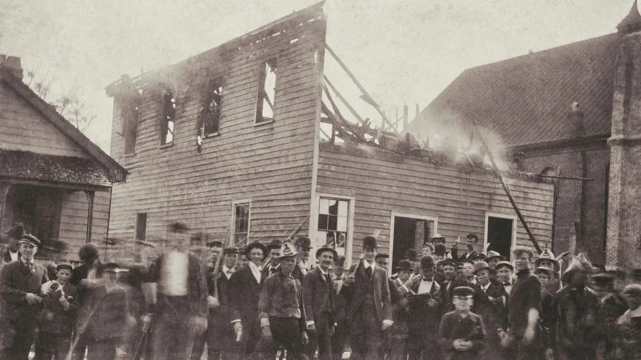 A historic photo of a crowd watching a building burn