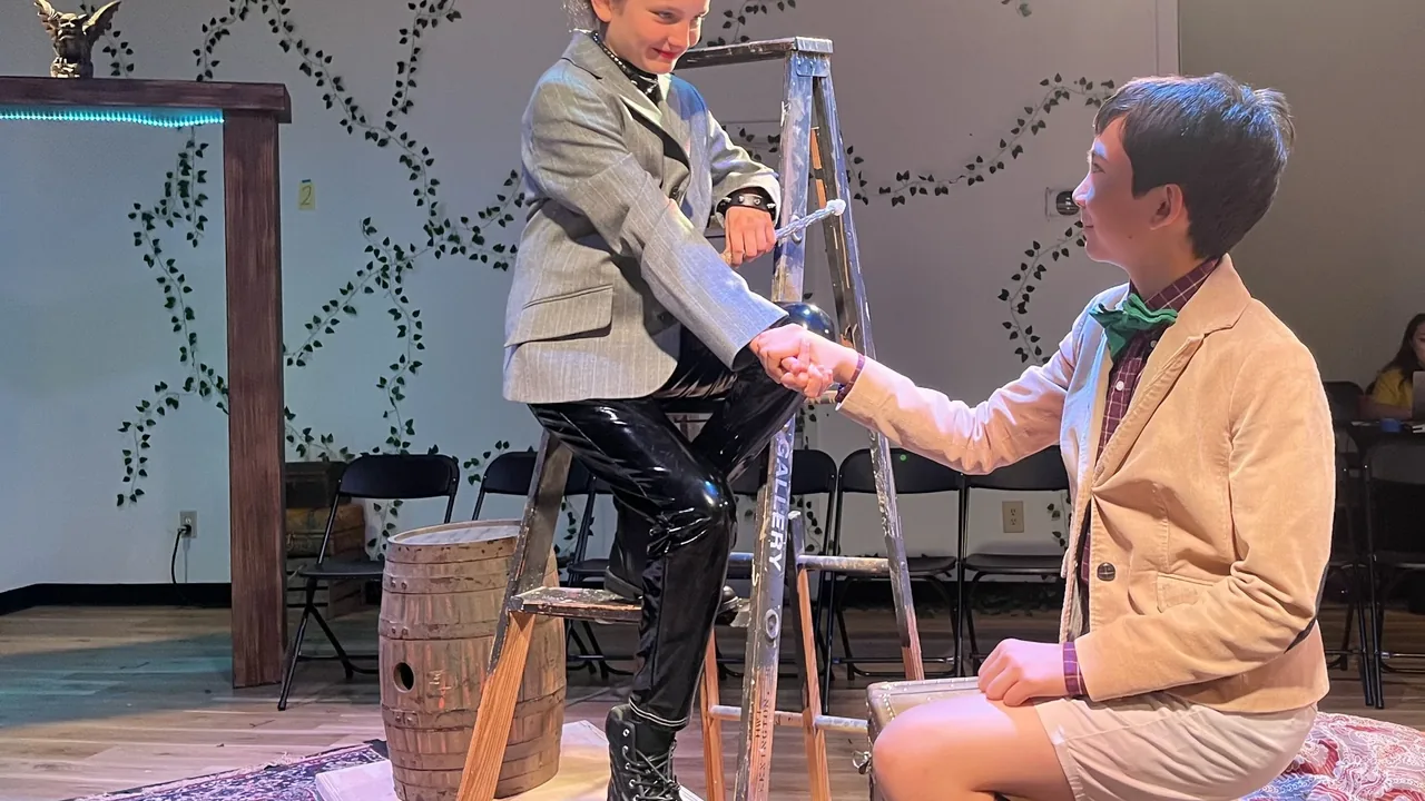 Two actors shake hands onstage
