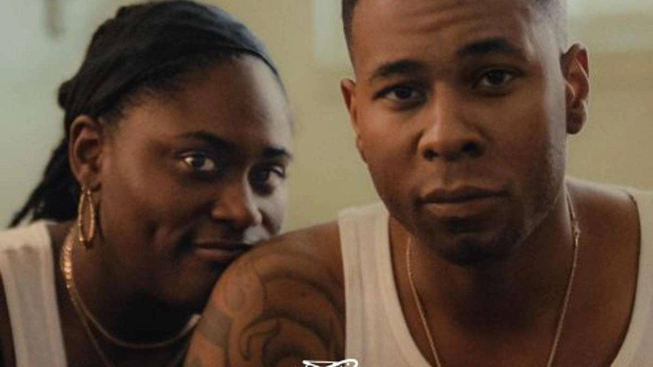 A young couple sits close together in a film still