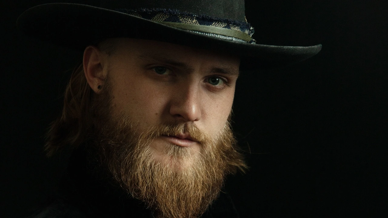 A bearded singer in a black hat
