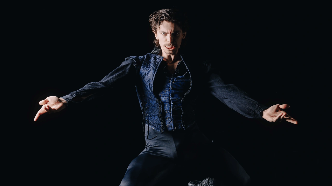 A dancer leaps against a black backdrop