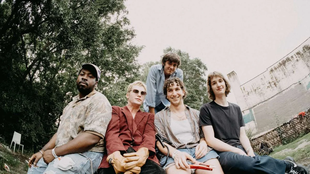 Four musicians sit outside together