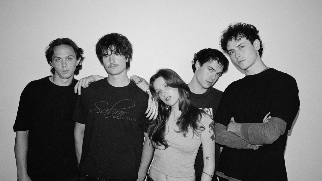 Five young musicians pose in black and white