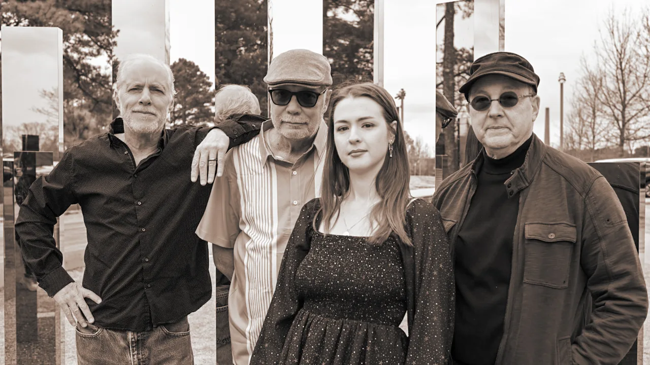 Four musicians pose in black and white