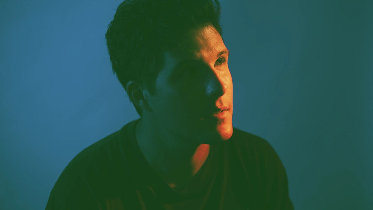 A moody portrait of a singer in teal light