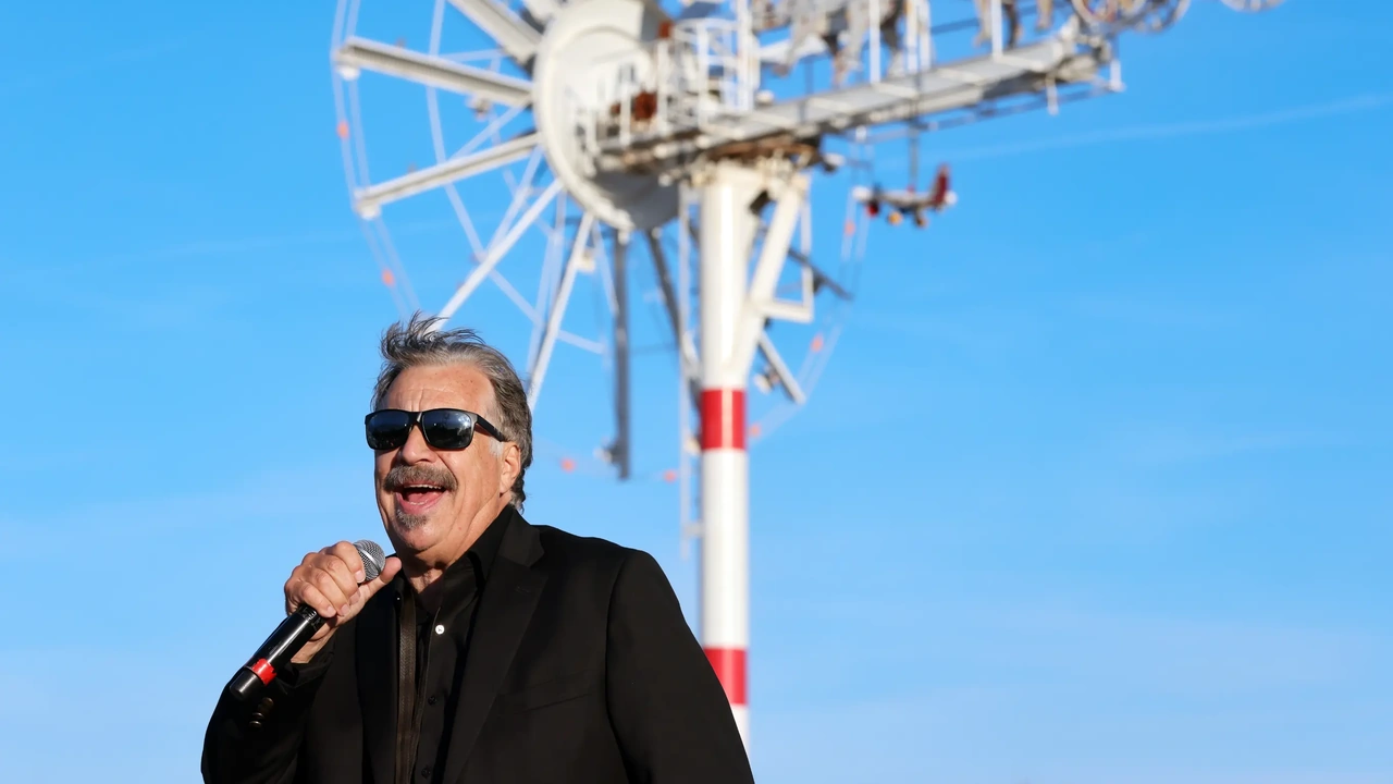 A singer in sunglasses performs outdoors