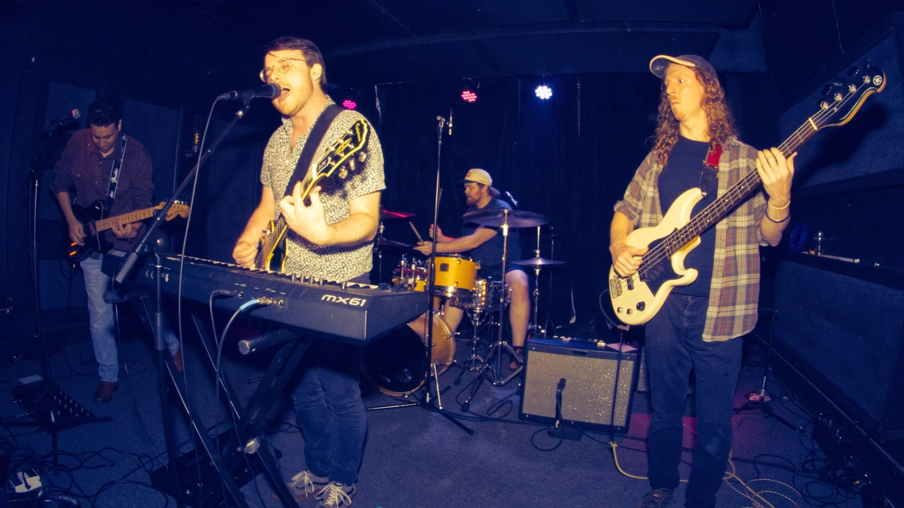 A band performs under blue stage lights