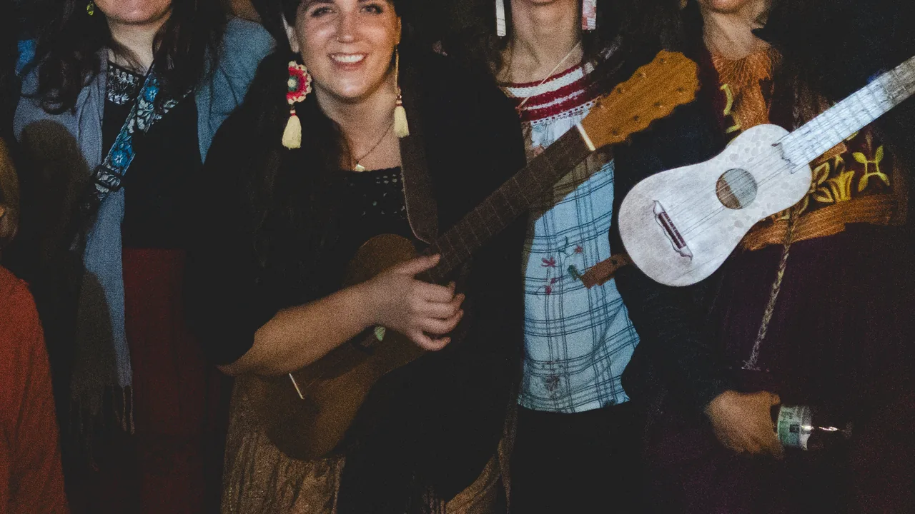 Women musicians play ukuleles and guitars together