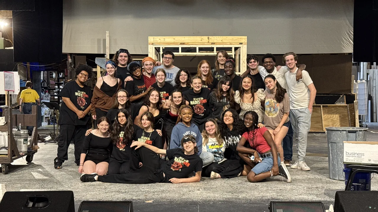 A theater cast gathers for a group photo backstage