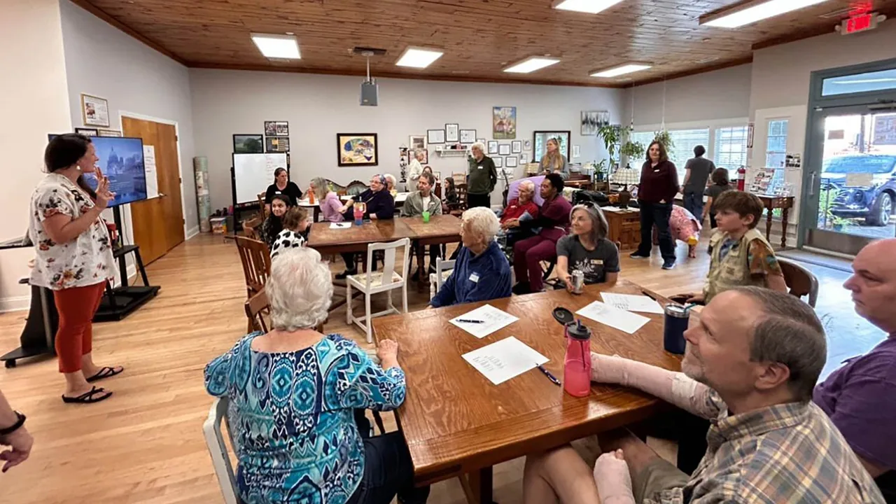 Neighbors gather at tables in a community room