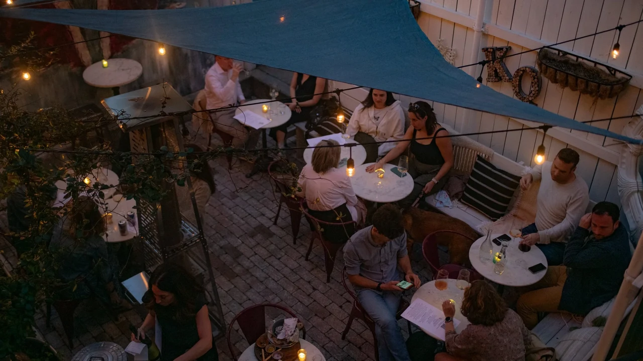 Guests on the string-lit patio at Queeny's in Durham