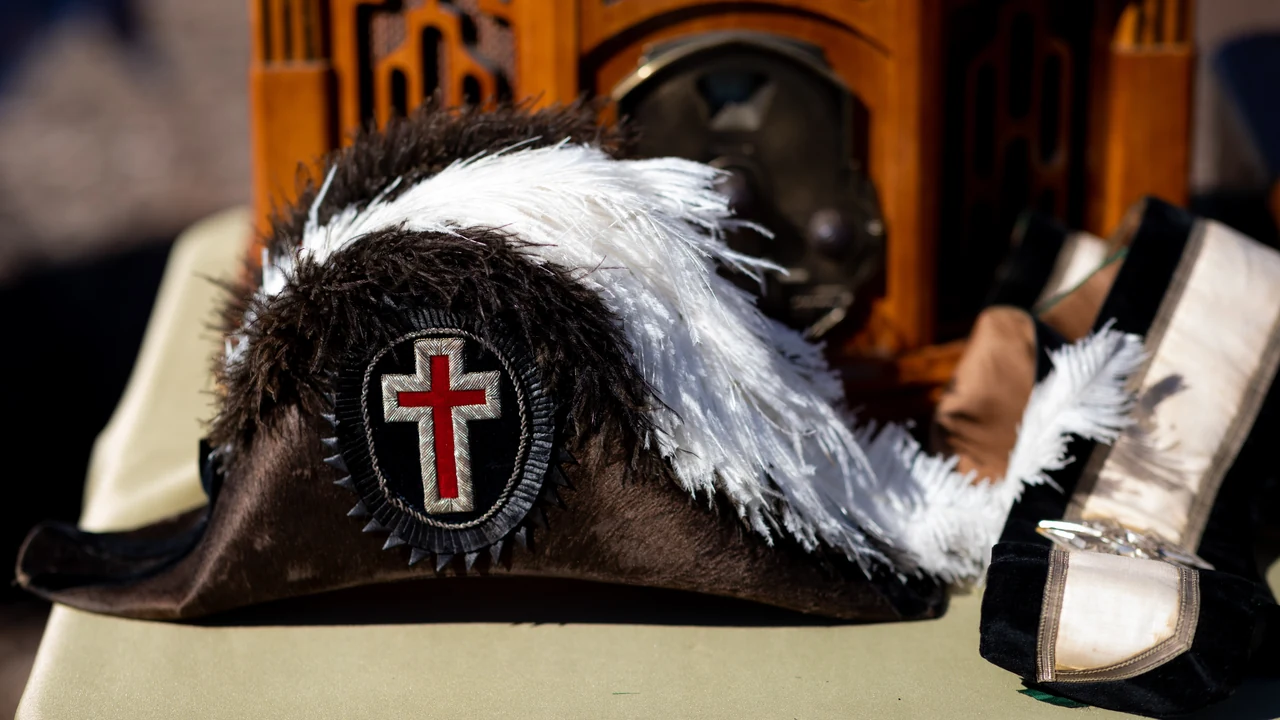 A plumed tricorn hat with a cross emblem