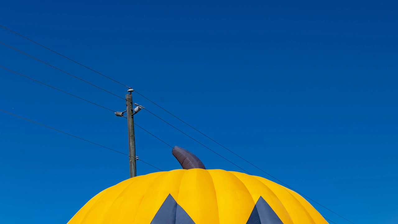 The top of a giant inflatable pumpkin against a blue sky
