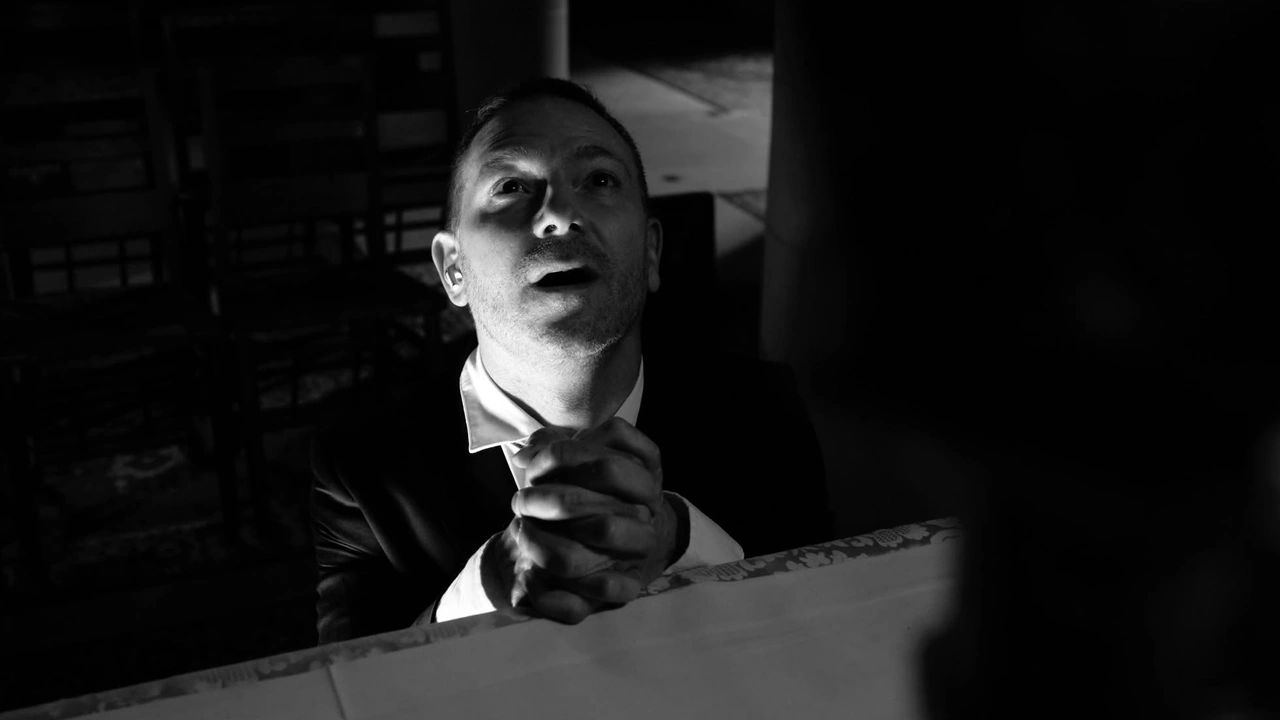 A man speaks in dramatic black-and-white light